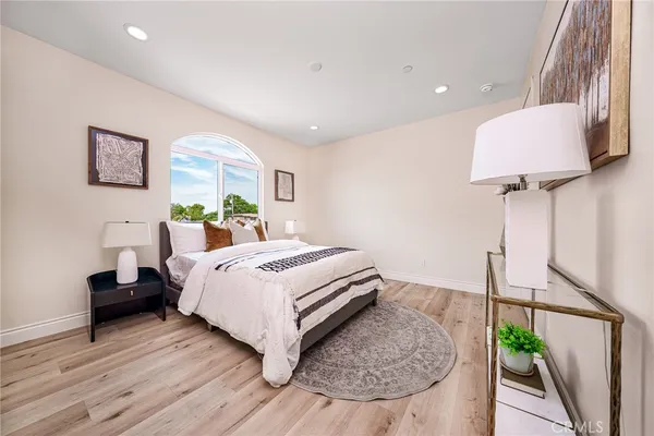 a bedroom with a bed and a potted plant on dresser