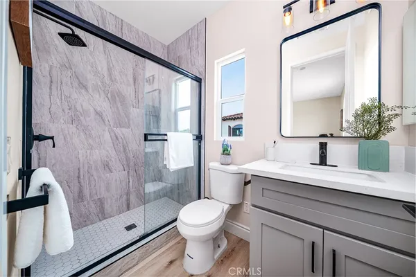 a bathroom with a granite countertop sink toilet a mirror and shower