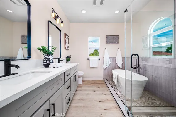 a spacious bathroom with double vanity and a bathtub