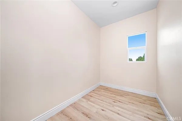 a view of a small space with wooden floor and a window