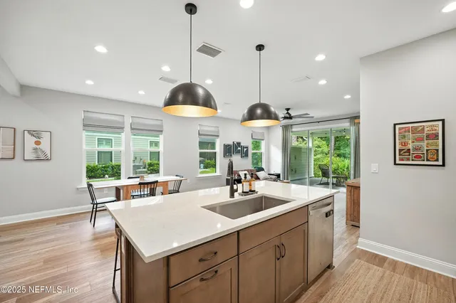 a kitchen with a sink window and wooden floor