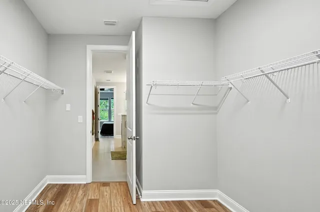 a view of walk in closet with wooden floor