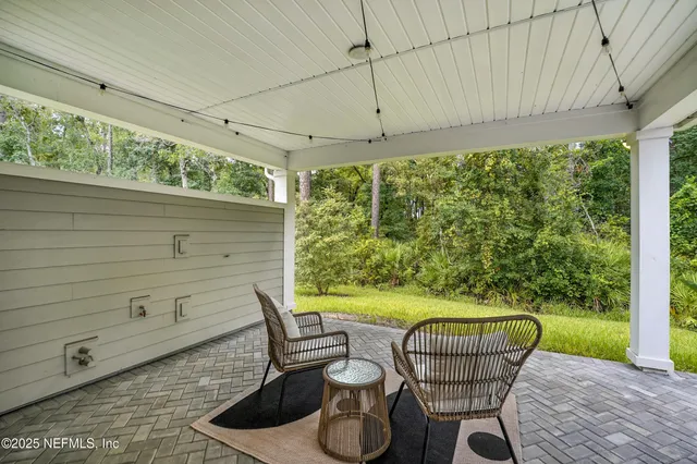 a view of a patio with a table and chairs under an umbrella