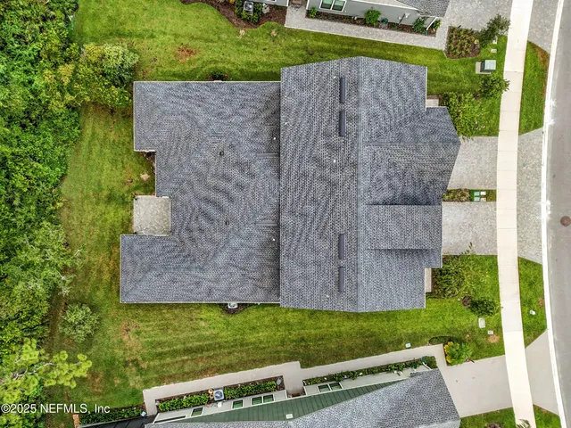 an aerial view of residential houses with outdoor space and trees