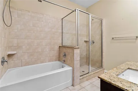 a bathroom with a granite countertop bathtub shower and sink