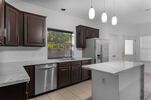a kitchen with a sink refrigerator and cabinets