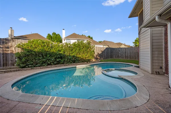a view of a swimming pool with a yard and plants