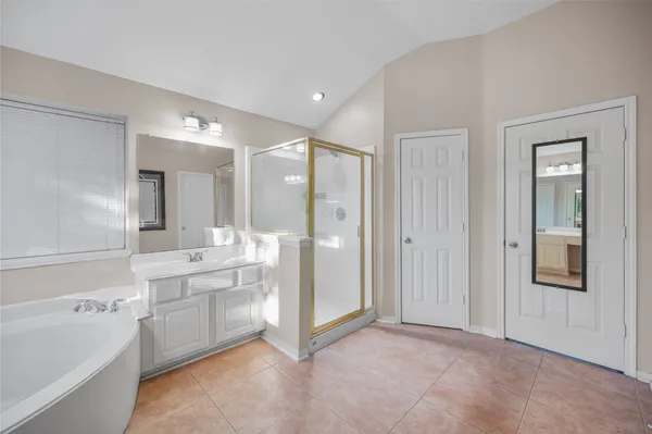 a large bathroom with a large mirror vanity and shower
