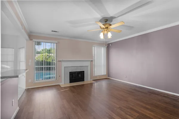 an empty room with windows and fireplace