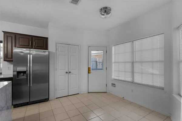a view of a refrigerator in kitchen and white cabinets