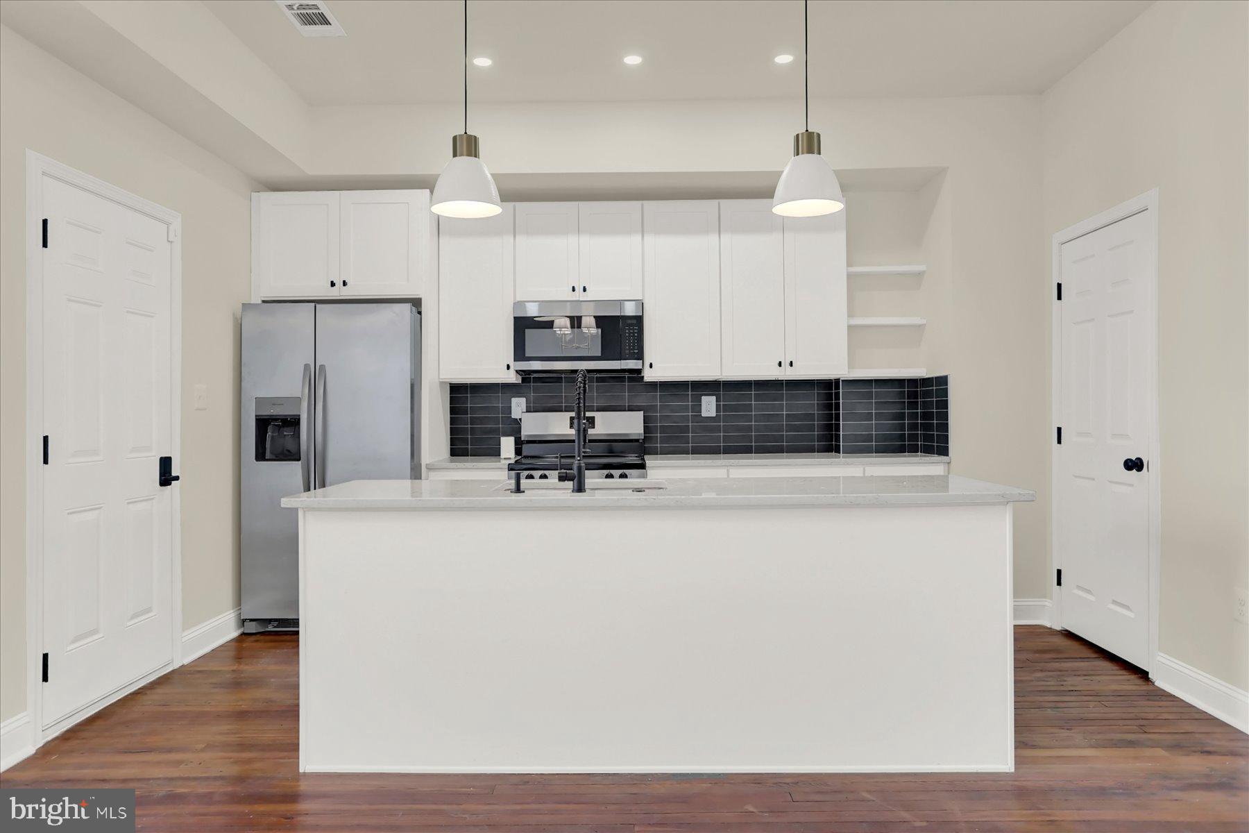 2920 Brighton Street Baltimore, MD 21216 - Photo 11 of 32 a view of kitchen with stainless steel appliances wooden floor and window