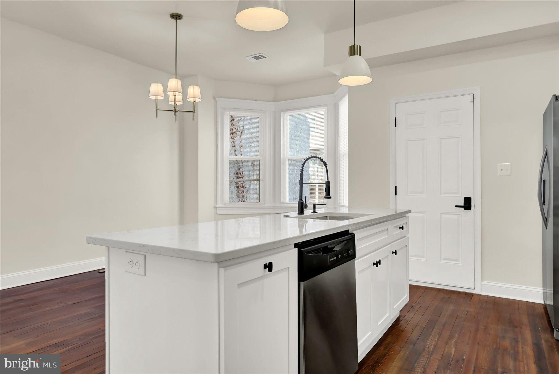 2920 Brighton Street Baltimore, MD 21216 - Photo 12 of 32 a view of a kitchen with a sink stainless steel appliances and wooden floor