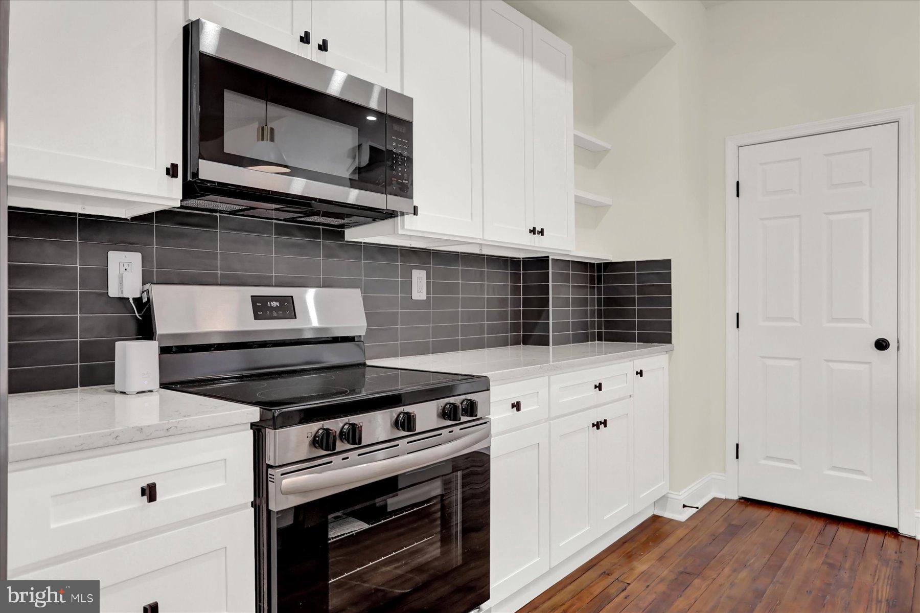 2920 Brighton Street Baltimore, MD 21216 - Photo 13 of 32 a kitchen with stainless steel appliances a stove a microwave and cabinets
