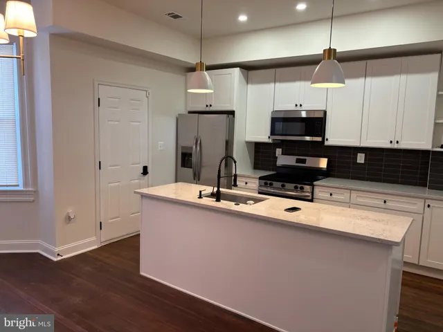 a kitchen with stainless steel appliances granite countertop a sink a stove and a refrigerator