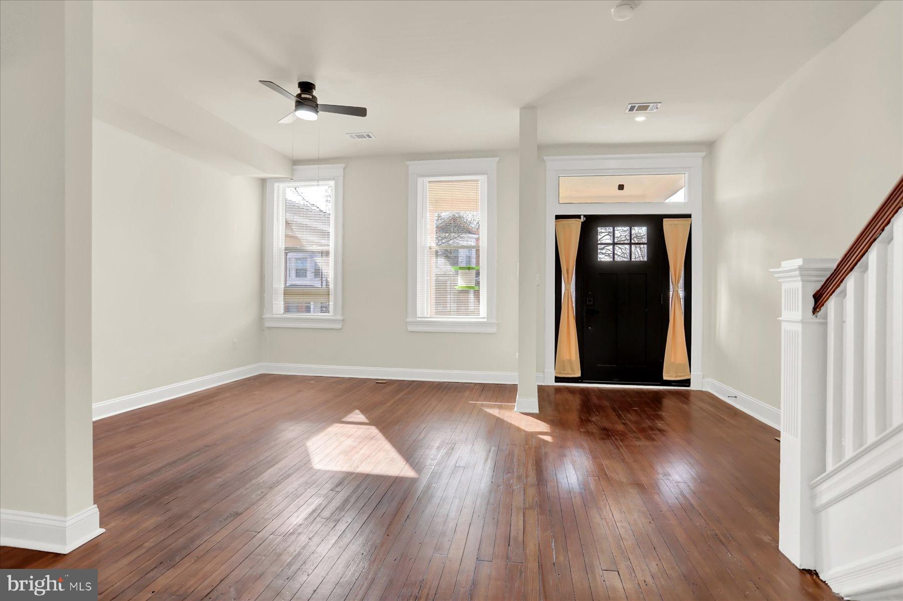 2920 Brighton Street Baltimore, MD 21216 - Photo 4 of 32 a view of an empty room with wooden floor and a window