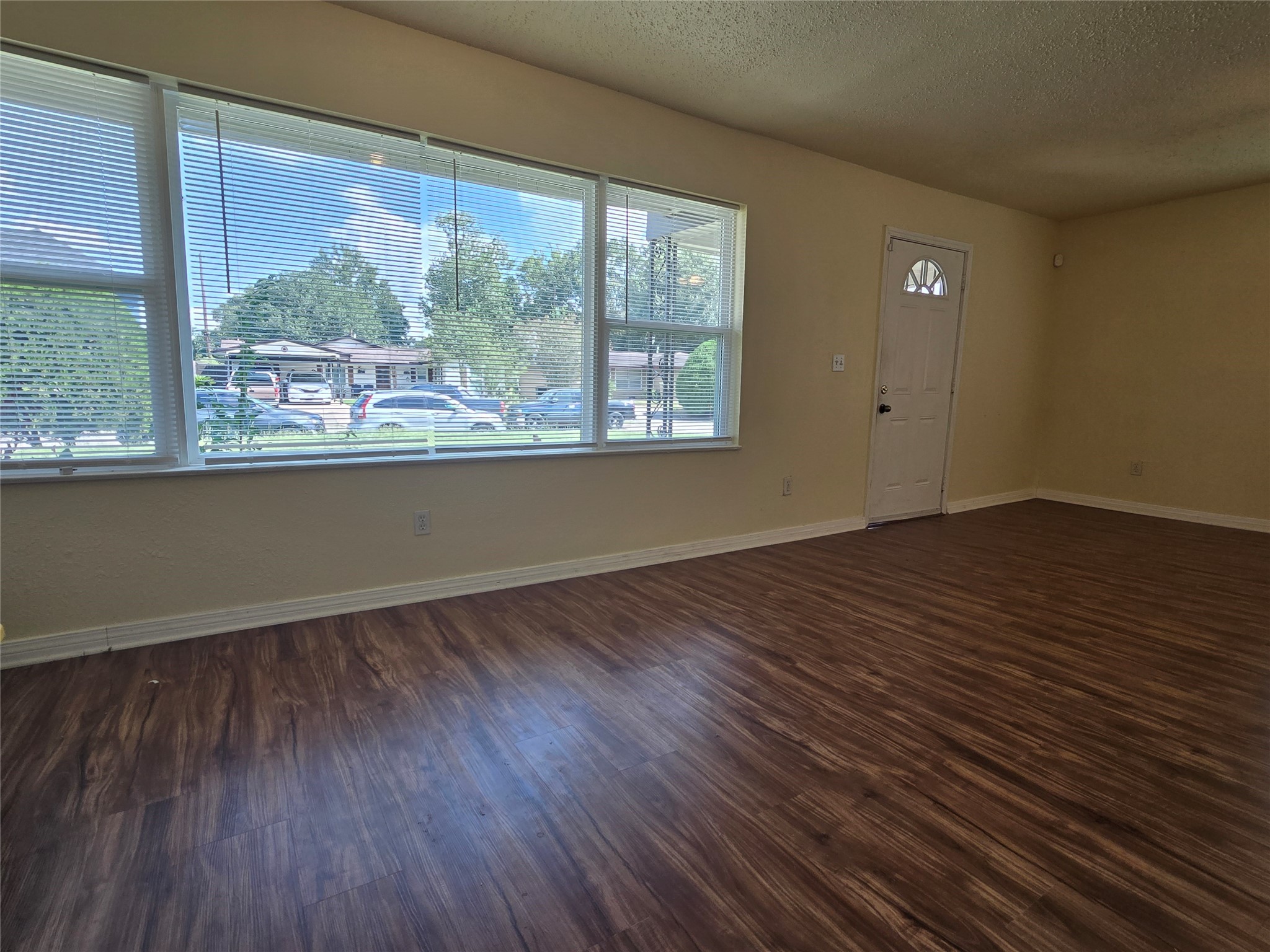 5218 Kelso Street Houston, TX 77021 - Photo 2 of 7 an empty room with wooden floor and windows