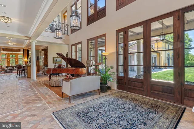 a living room with furniture large window and wooden floor