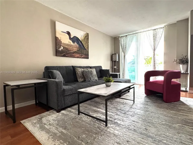 a living room with furniture a rug and a window
