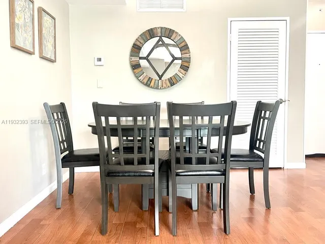 a view of a dining room with furniture wooden floor and next to a window