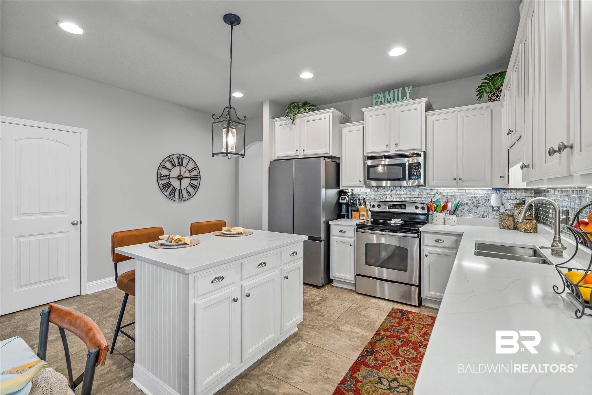 10677 Orkney Way Spanish Fort, AL 36527 - Photo 6 of 22 Kitchen with white cabinets, a breakfast bar, tasteful backsplash, stainless steel appliances, and recessed lighting