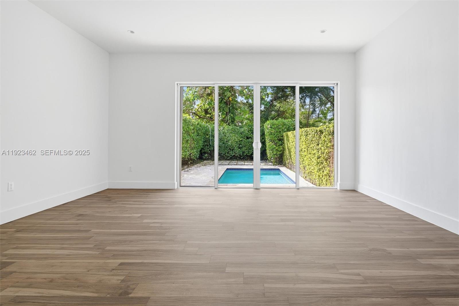 2852 Southwest 32nd Court, Unit 2852 Miami, FL 33133 - Photo 12 of 50 a view of an empty room with wooden floor and a window