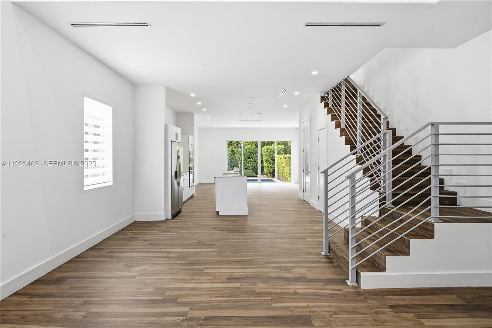 2852 Southwest 32nd Court, Unit 2852 Miami, FL 33133 - Photo 14 of 50 a view of an empty room with wooden floor and windows