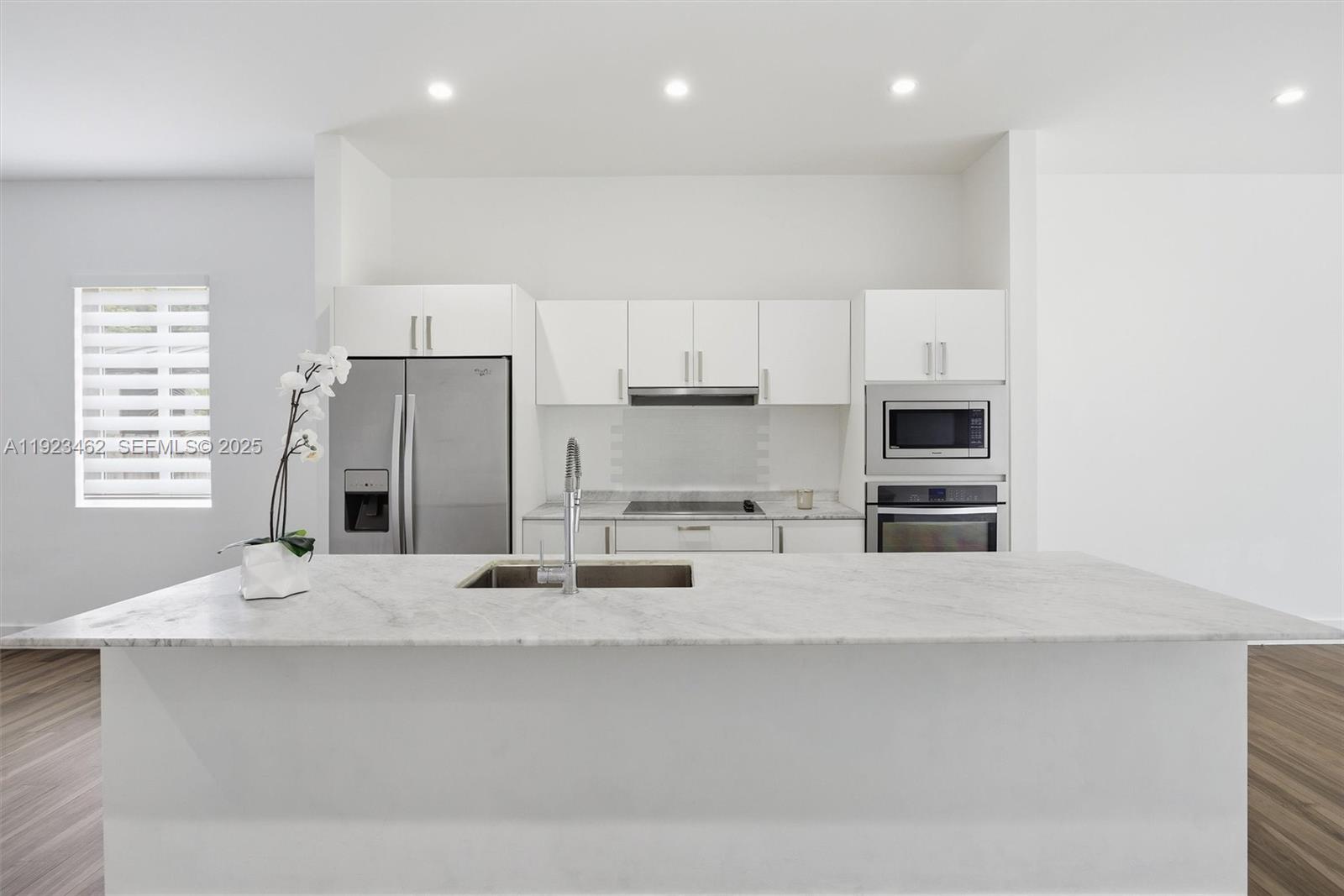 2852 Southwest 32nd Court, Unit 2852 Miami, FL 33133 - Photo 18 of 50 a kitchen with stainless steel appliances a sink a stove a microwave a refrigerator and white cabinets
