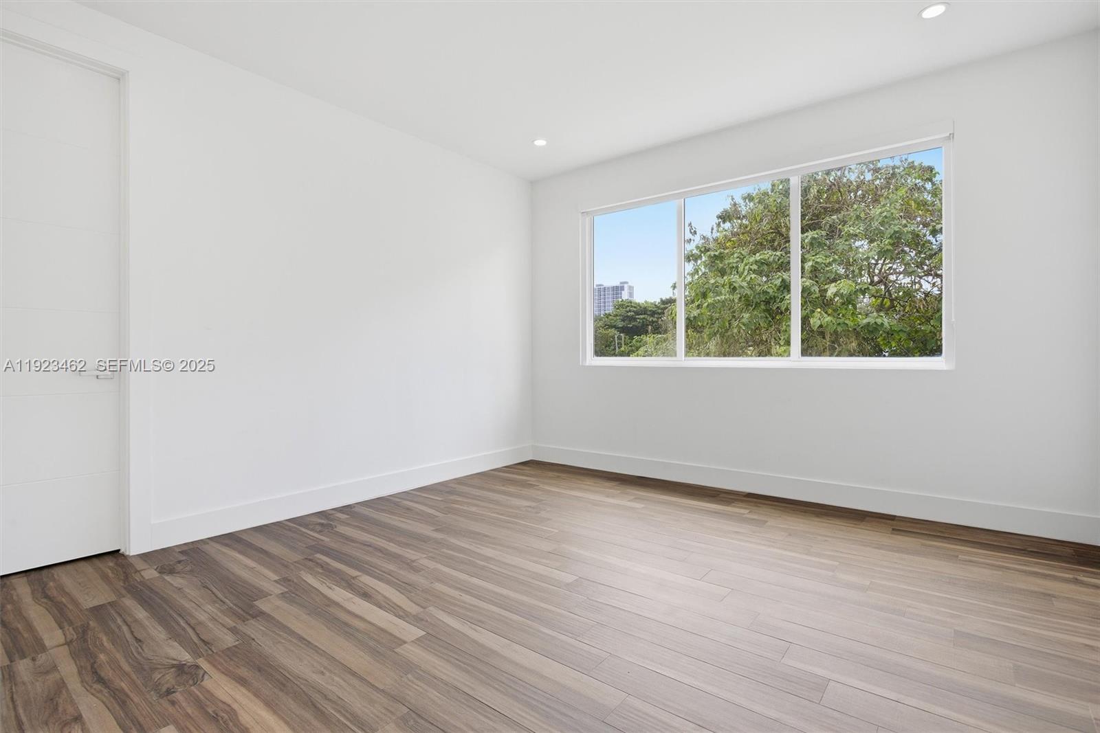 2852 Southwest 32nd Court, Unit 2852 Miami, FL 33133 - Photo 21 of 50 an empty room with wooden floor and windows