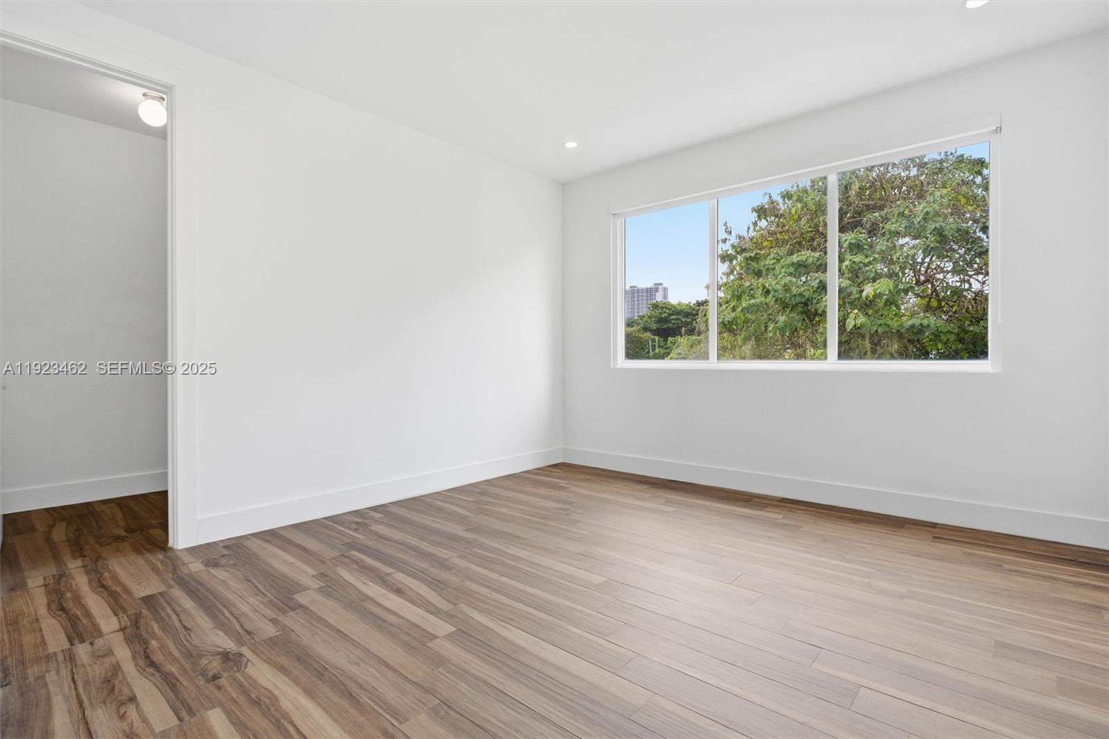 2852 Southwest 32nd Court, Unit 2852 Miami, FL 33133 - Photo 22 of 50 an empty room with wooden floor and windows