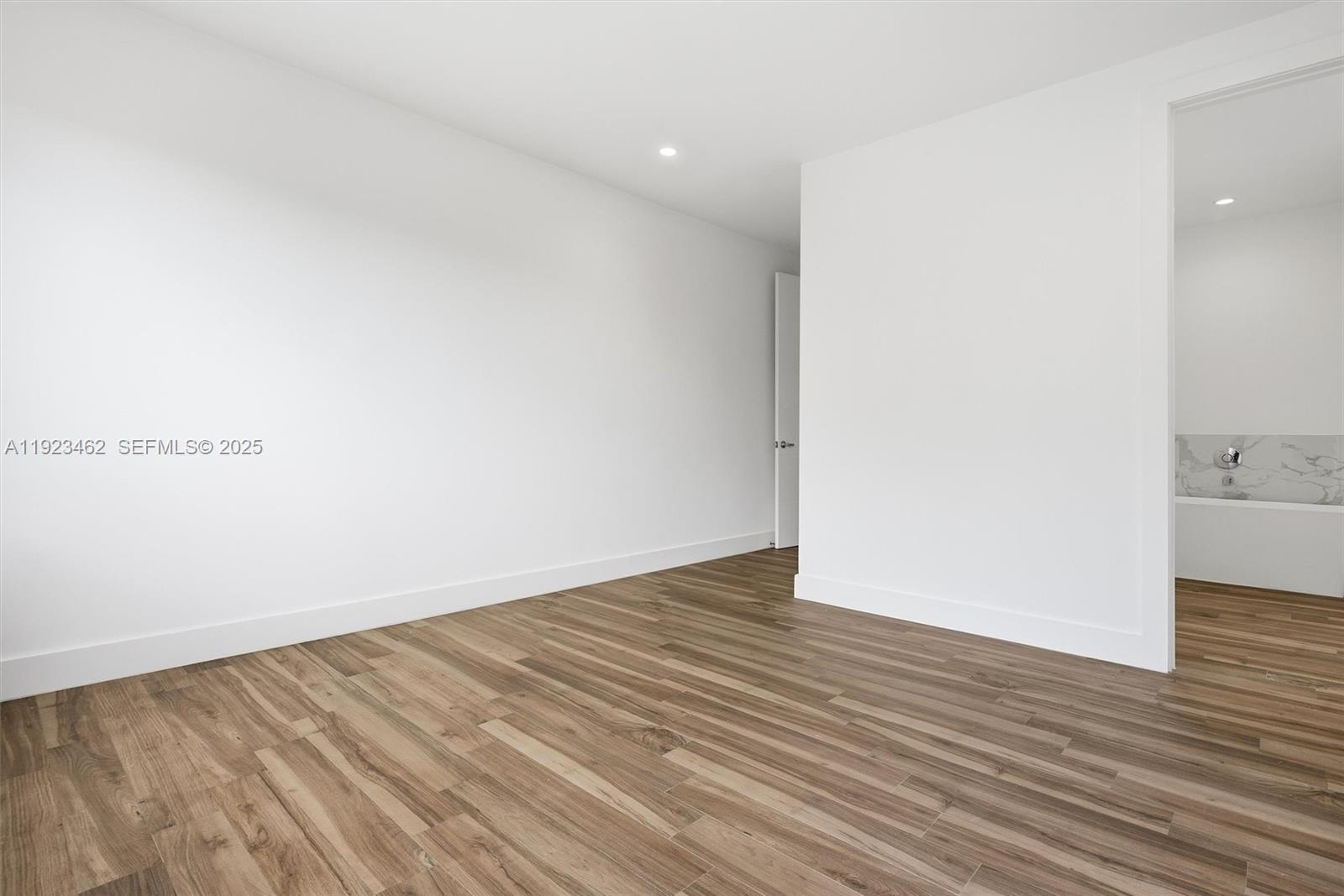 2852 Southwest 32nd Court, Unit 2852 Miami, FL 33133 - Photo 24 of 50 a view of an empty room with wooden floor and a bathroom