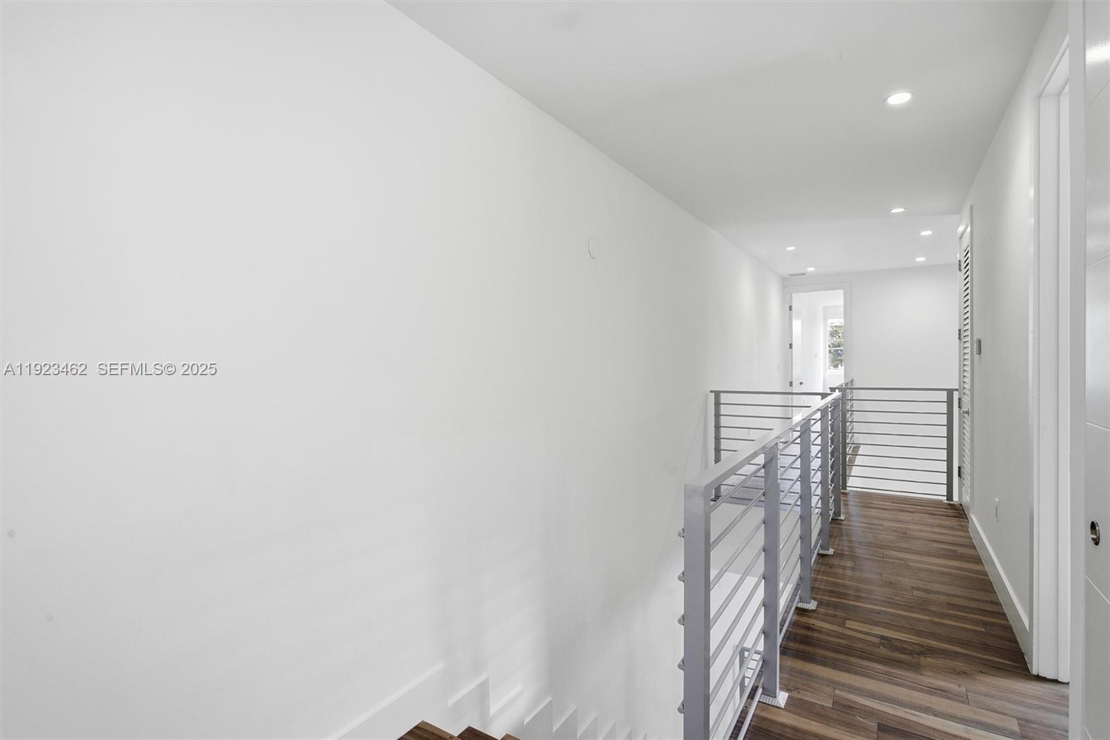 2852 Southwest 32nd Court, Unit 2852 Miami, FL 33133 - Photo 30 of 50 a hallway with wooden floor stairs and a chandelier