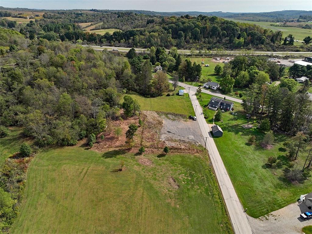 an aerial view of residential houses with outdoor space and trees