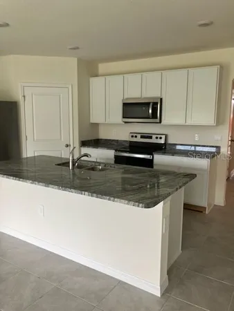 a kitchen with stainless steel appliances granite countertop a sink stove and microwave
