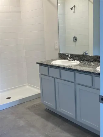 a bathroom with a granite countertop sink and a bathtub