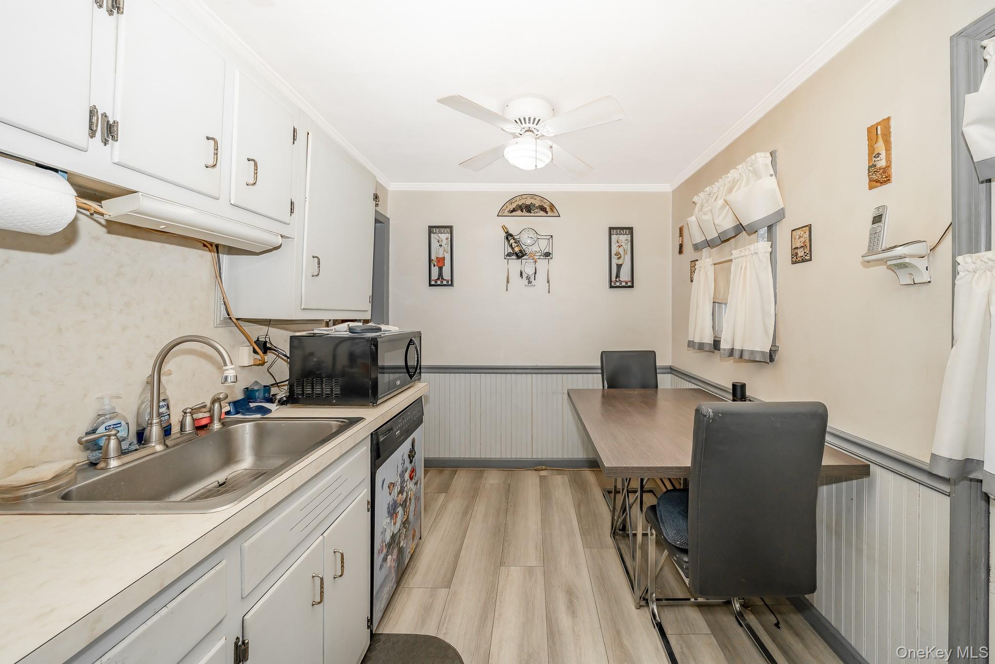 3683 Hawk Road Levittown, NY 11756 - Photo 17 of 41 a view of a kitchen with kitchen island a sink wooden floor and a dining table