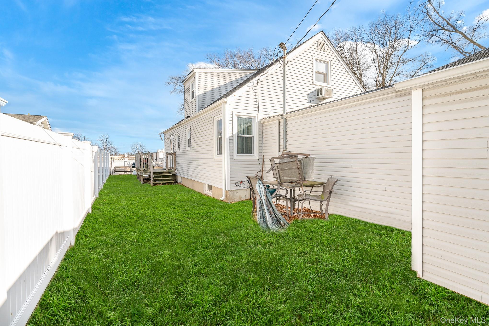 3683 Hawk Road Levittown, NY 11756 - Photo 6 of 41 a view of a backyard with table and chairs and a grill