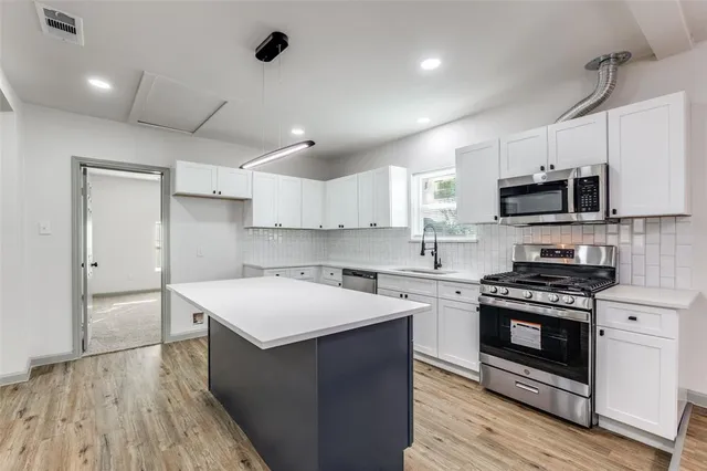 a kitchen with a stove a sink and a microwave