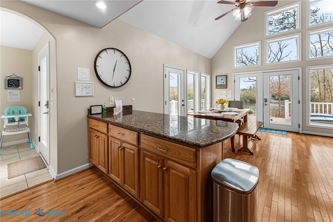 4775 Stormont Road Hartfield, VA 23071 - Photo 26 of 45 Kitchen with a peninsula, wood finish cabinetry, french doors, dark stone counters, and light wood-style floors