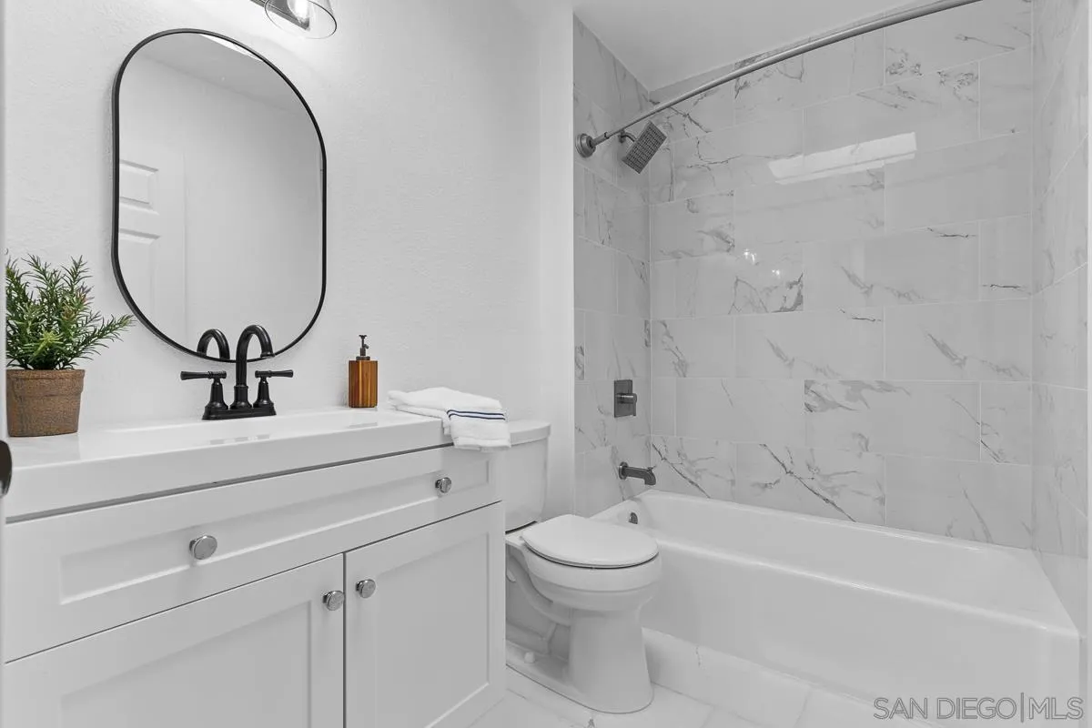 981 North Vulcan Avenue, Unit 4 Encinitas, CA 92024 - Photo 15 of 24 a bathroom with a toilet a sink and a mirror