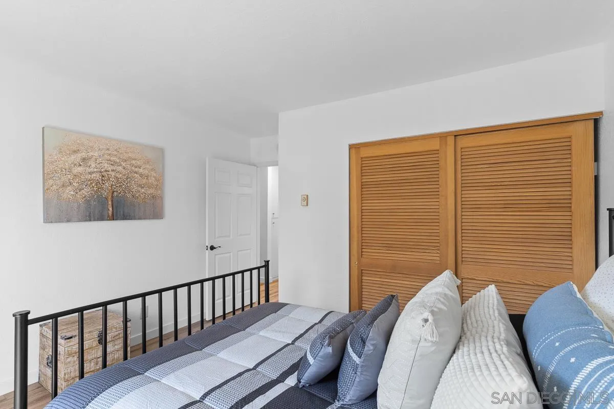 981 North Vulcan Avenue, Unit 4 Encinitas, CA 92024 - Photo 17 of 24 a bedroom with a bed and wooden floor