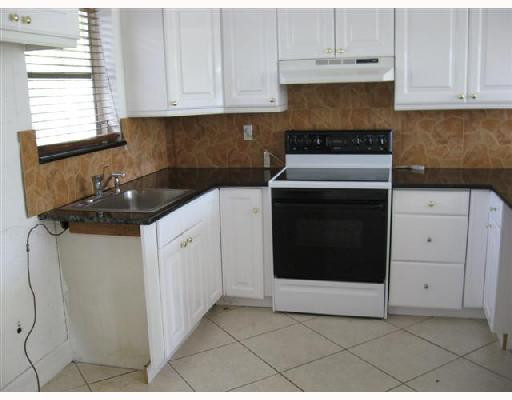 6301 Southwest 3rd Street Pompano Beach, FL 33068 - Photo 6 of 13 a kitchen with granite countertop white cabinets and white appliances