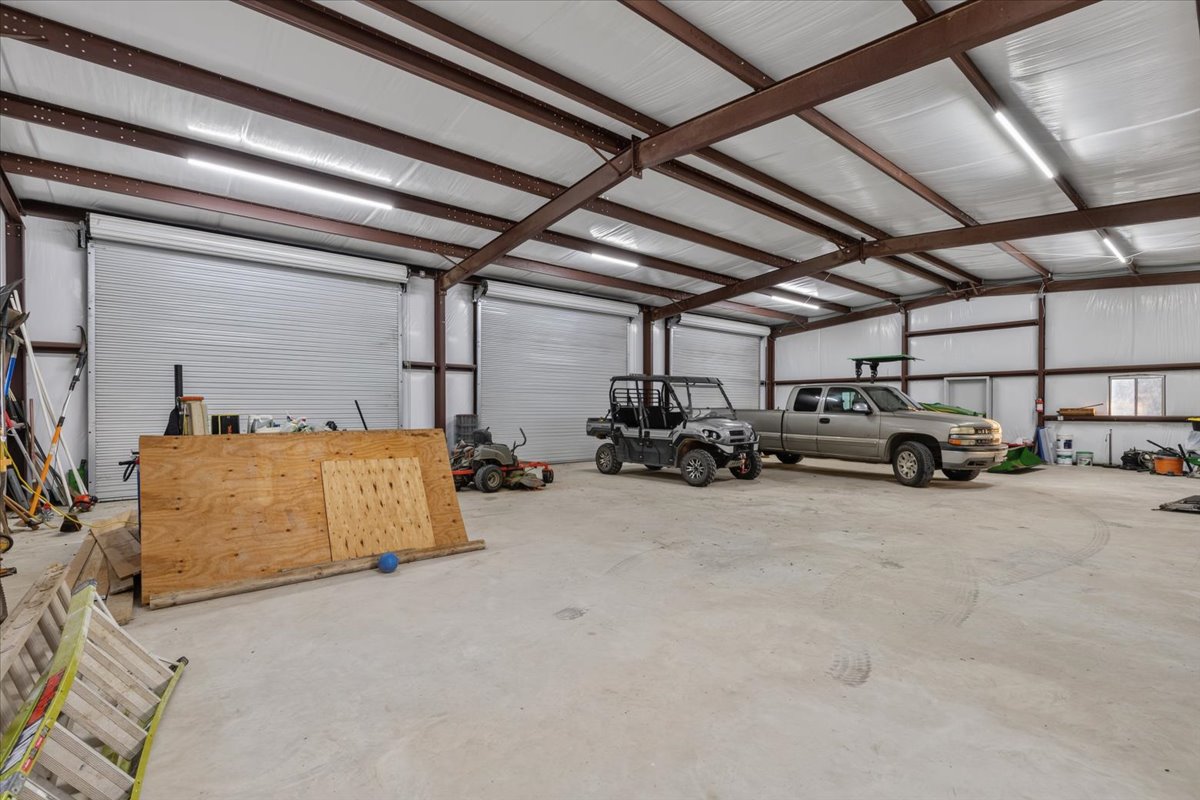 175 Wilson Road Elgin, TX 78621 - Photo 36 of 40 Inside the workshop, you can see just how massive it really is! It’s fully insulated overhead with bright LED strip lighting, high steel-truss ceilings, and smooth concrete floors. There is more than enough room to park trucks, UTVs, trailers, lawn mowers, and still have space for a full shop.