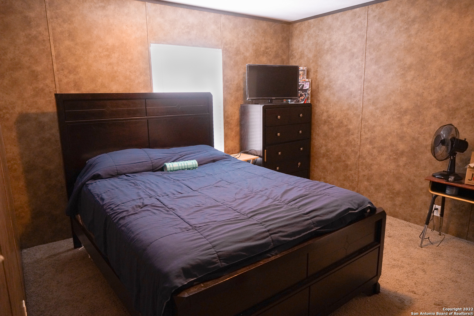 10179 Commerce Street Atascosa, TX 78002 - Photo 11 of 12 a bedroom with a bed and a tv on a stool