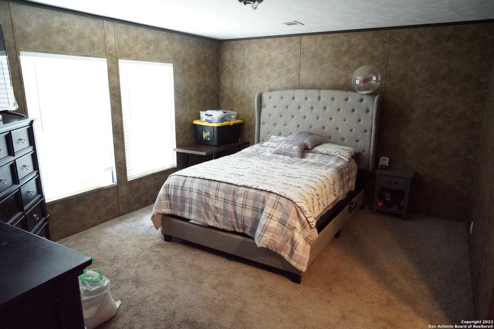 10179 Commerce Street Atascosa, TX 78002 - Photo 10 of 12 a bedroom with a bed and a flat tv screen on a dresser