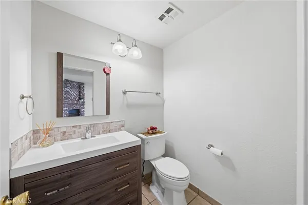 a bathroom with a sink vanity mirror and toilet