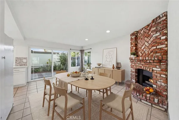 a dining room with furniture a fireplace and wooden floor