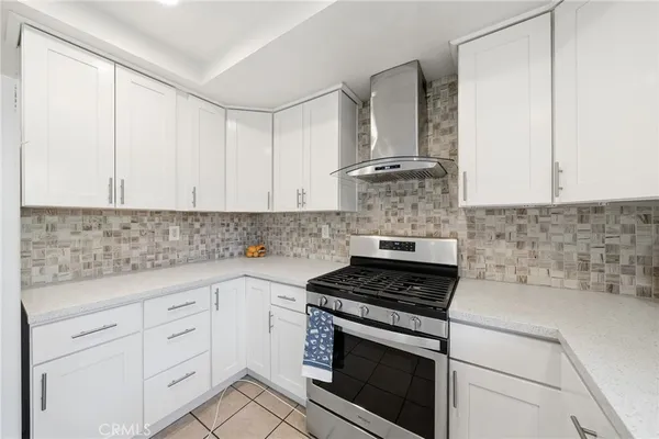 a kitchen with white cabinets and appliances