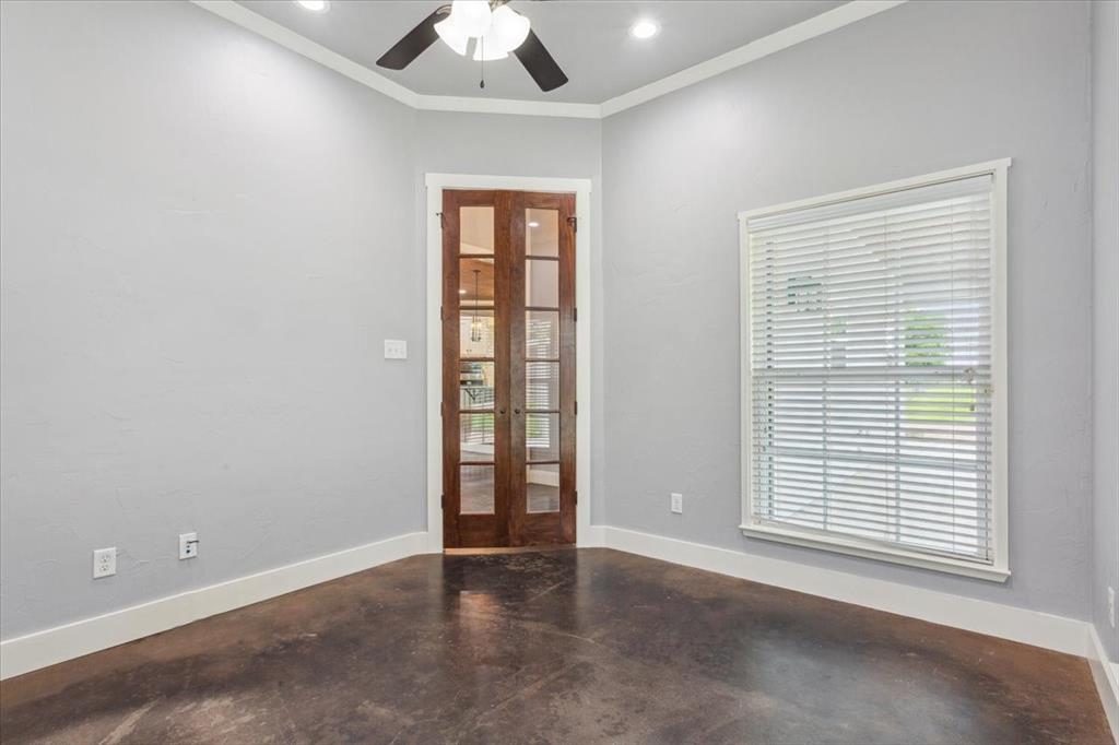 259 County Road 149 Riesel, TX 76682 - Photo 14 of 40 Unfurnished room with french doors, finished concrete flooring, healthy amount of natural light, ceiling fan, and crown molding