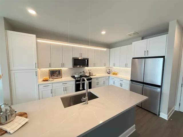 a kitchen with white cabinets and stainless steel appliances