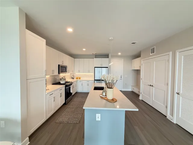 a kitchen with white cabinets and stainless steel appliances